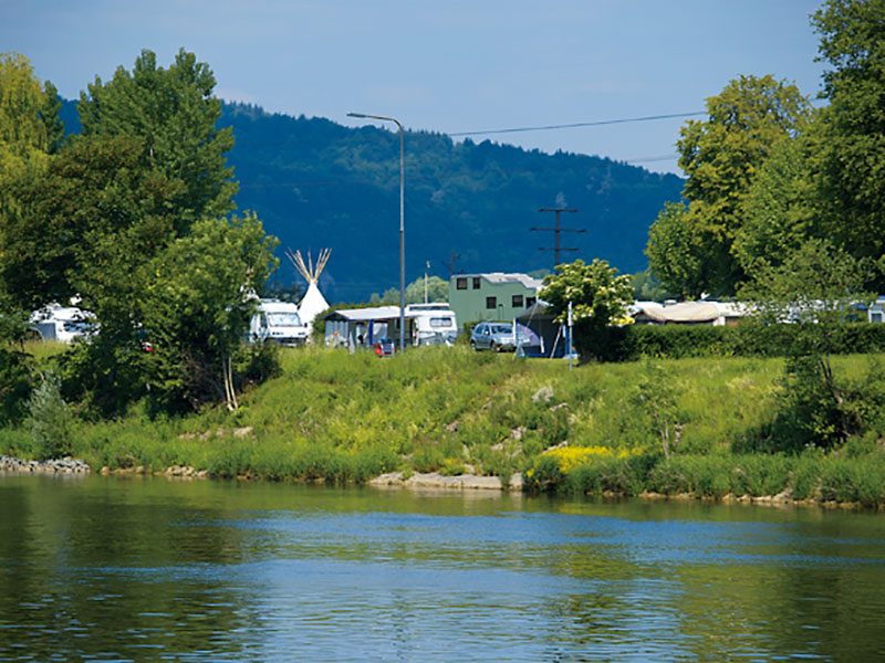 Blick über den Neckar auf Wohnwagen und Zelte am Ufer des Campingplatzes Cimbria